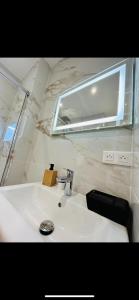 uma casa de banho com um lavatório branco e um espelho. em Studio Promenade des Anglais em Nice