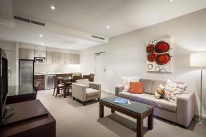 a living room with a couch and a table at Quest Alice Springs in Alice Springs