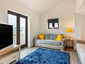 un soggiorno con divano e TV di Hillsview - 4 berth renovated barn conversion a Combe Martin