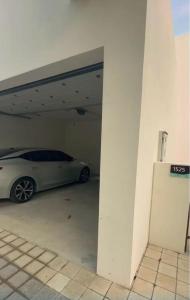 a white car parked in a parking garage at LUXURY 4 Bedroom Private Pool Villa at THE WAVE in Muscat