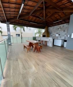 duży pokój ze stołem i 2 ławkami w obiekcie Aconchego Urbano: Espaçoso C/Ar w mieście Feira de Santana