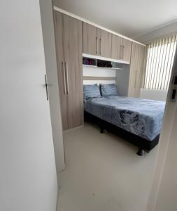 1 dormitorio con 1 cama en una habitación con armarios en Aconchego Urbano: Espaçoso C/Ar, en Feira de Santana