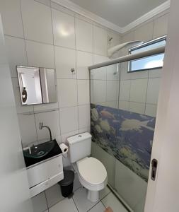 a small bathroom with a toilet and a sink at Aconchego Urbano: Espaçoso C/Ar in Feira de Santana