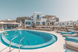 une grande piscine avec des chaises et une maison dans l'établissement Villa Konstantin, à Mykonos