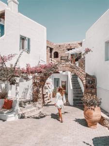 a woman walking through an archway in a building at Villa Konstantin in Mikonos