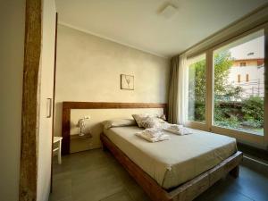 A bed or beds in a room at Villa Fontanelle Gardapartments