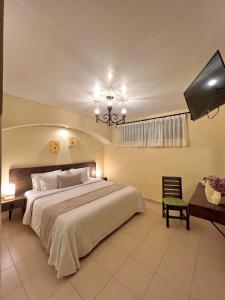 - une chambre avec un grand lit et une télévision dans l'établissement Hotel Del Parque, à Huamantla