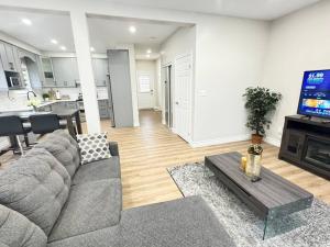 a living room with a gray couch and a tv at Luxury Private home near Sunrise Shopping Complex in Kitchener