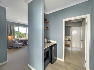 a kitchen with blue walls and a living room at Figtree Retreat in Rothbury
