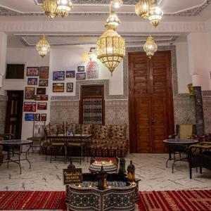 - un salon avec un canapé, des tables et des lustres dans l'établissement Riad bel kaid fes, à Fès