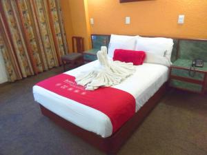 um quarto com uma cama grande e um cobertor vermelho em Hotel Central em Ciudad Nezahualcóyotl
