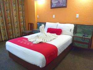 Una habitación de hotel con una cama con una toalla. en Hotel Central, en Ciudad Nezahualcóyotl