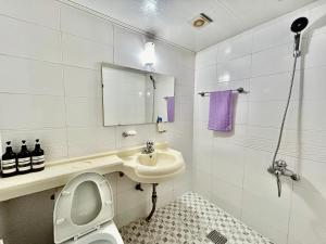 ein weißes Bad mit einem WC und einem Waschbecken in der Unterkunft A ONE Motel in Geoje