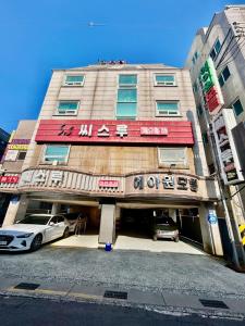 ein Gebäude mit zwei davor geparkt in der Unterkunft A ONE Motel in Geoje