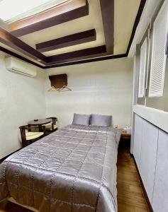 Schlafzimmer mit einem Bett und einem Tisch in der Unterkunft A ONE Motel in Geoje