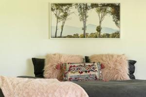 un sofá con almohadas peludas y una foto en la pared en Linleigh Farmhouse With Mountain Views, en Barwite