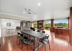 a dining room and living room with a table and chairs at Blissful Bungalow Batemans Bay managed by Batemans Bay Accom in Batemans Bay
