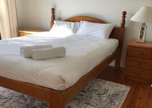 DurrasにあるCarr Street Murramurang National Park managed by Batemans Bay Accomのベッド(白いシーツ、枕2つ付)