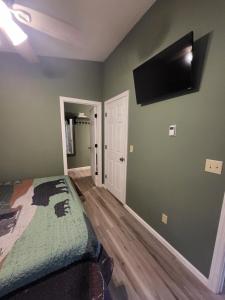 a bedroom with a bed and a flat screen tv on the wall at HB North Bears Lair in Thomas