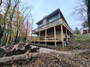 een groot huis met een veranda rondom in het bos bij HB North Bears Lair in Thomas