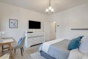 - une chambre avec un lit et un bureau avec une télévision dans l'établissement Charming downtown Livermore Flat - Private Living space, à Livermore