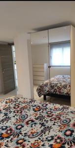 a bedroom with a bed with a floral comforter at Superbe appartement JO 2024 in Plaisir