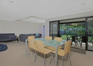 a dining room with a glass table and chairs at Sandy Place 75B Seaside Living in Long Beach