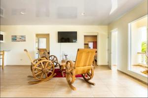 a living room with two wooden chairs and a wooden wagon at apartamento EL CORAL in Río San Juan