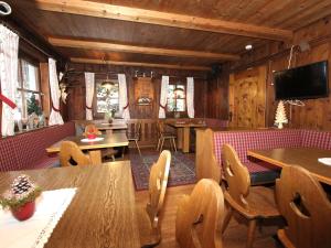 uma sala de jantar com paredes e mesas e cadeiras de madeira em Alpenhaus Lacknerbrunn em Mayrhofen