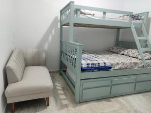 a bedroom with a bunk bed and a chair at Vitoria Hostel in Guarulhos