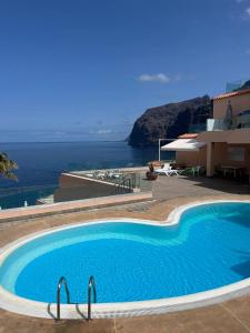 une grande piscine avec vue sur l'océan dans l'établissement Los Gigantes Buenavista Ocean View Apartment, à Acantilado de los Gigantes