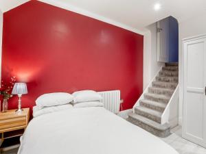 1 dormitorio con pared roja y cama blanca en Dragon Pad - Uk46422 en Royal Tunbridge Wells