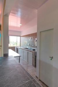 a large kitchen with white cabinets and a sliding door at THE HOUSE of FLOWERS in Melgar