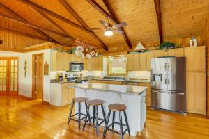 a large kitchen with a counter and stools in it at Duck and Bugs Cabin on Boone Lake with Boat Dock! in Piney Flats
