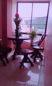 una mesa con flores en una habitación con ventana en HOSTAL EL CASTILLO SIGCHOS, en Sigchos