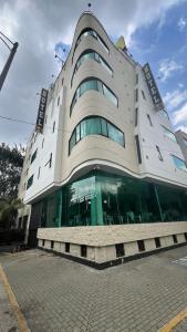 un gran edificio con ventanas de cristal en una calle en Hotel Gran Conquistador 33 en Medellín