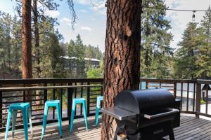a grill sitting on a deck next to a tree at LOGE Leavenworth Riverside in Leavenworth