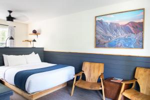 um quarto com uma cama e 2 cadeiras em LOGE Leavenworth Riverside em Leavenworth