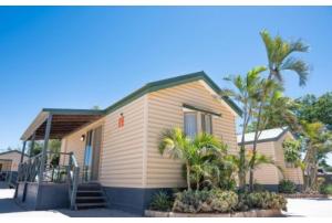a small house with palm trees in front of it at Discovery Parks - Carnarvon in Carnarvon