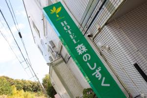 a green sign hanging from the side of a building at ホテル森のしずく in Katsura