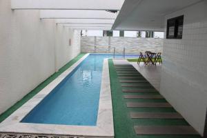 una piscina en un edificio con agua azul en Apt Completo, 2 QTS, 2 WC e próx ao mar, en Recife