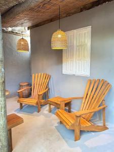 two chairs and a table in a room at Pousada Odara Caraíva in Porto Seguro