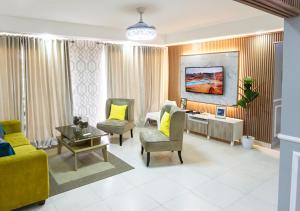 sala de estar con sofá amarillo y sillas en Apartamento Frente a la Zona Colonial, Santo Domingo, en Santo Domingo