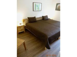 een slaapkamer met een bed en een houten vloer bij Classy apartment in Soultzeren in Soultzeren