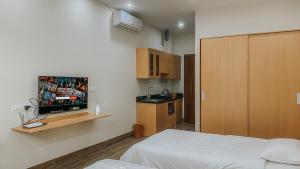 Habitación con cama, TV y cocina. en Yen’s House en Hanói