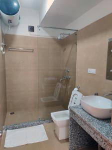 a bathroom with a sink and a toilet and a shower at Happy apartment in Thimphu