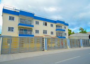 a building behind a fence on the side of a street at Suite in San Pedro De Macoris in San Pedro de Macorís