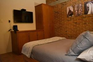 - une chambre avec un lit et un mur en briques dans l'établissement CASAS FREDA - Centro Historico Departamentos, à San Luis Potosí