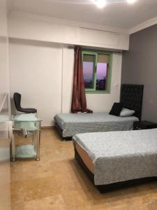 1 dormitorio con 2 camas, escritorio y ventana en Apartment Majorelle Garden With Pool, en Marrakech