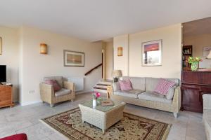 a living room with two couches and a table at Glendale Saundersfoot in Saundersfoot